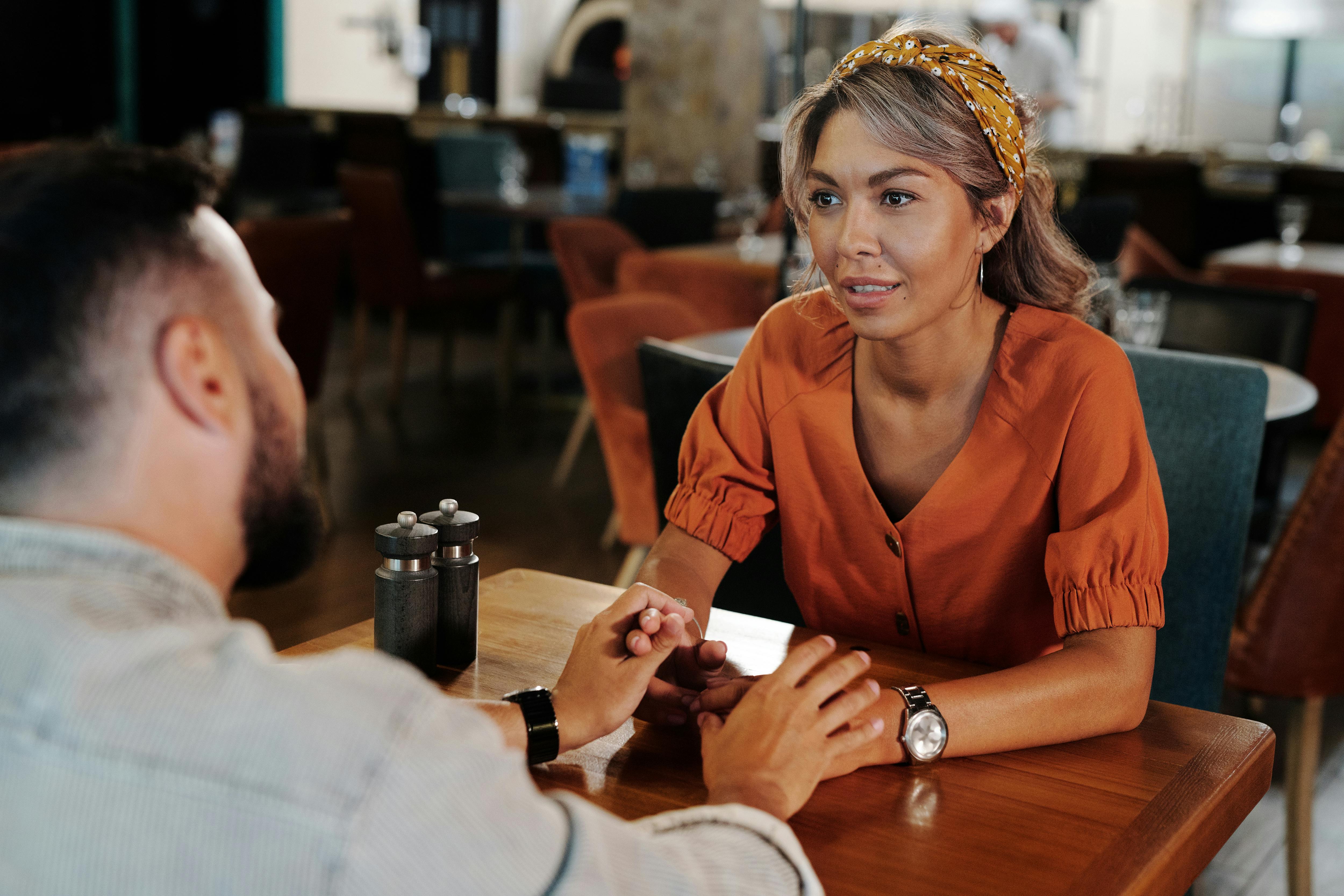 a couple holding hands on a date inside a restaurant