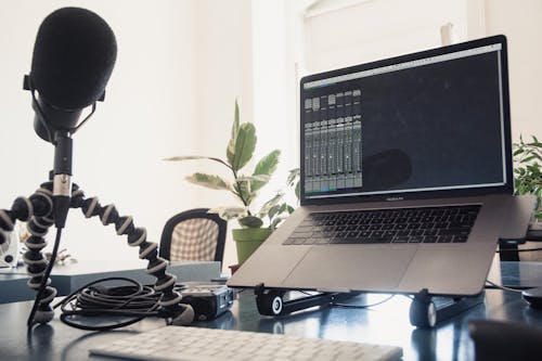 A Laptop Beside a Microphone in a Studio 