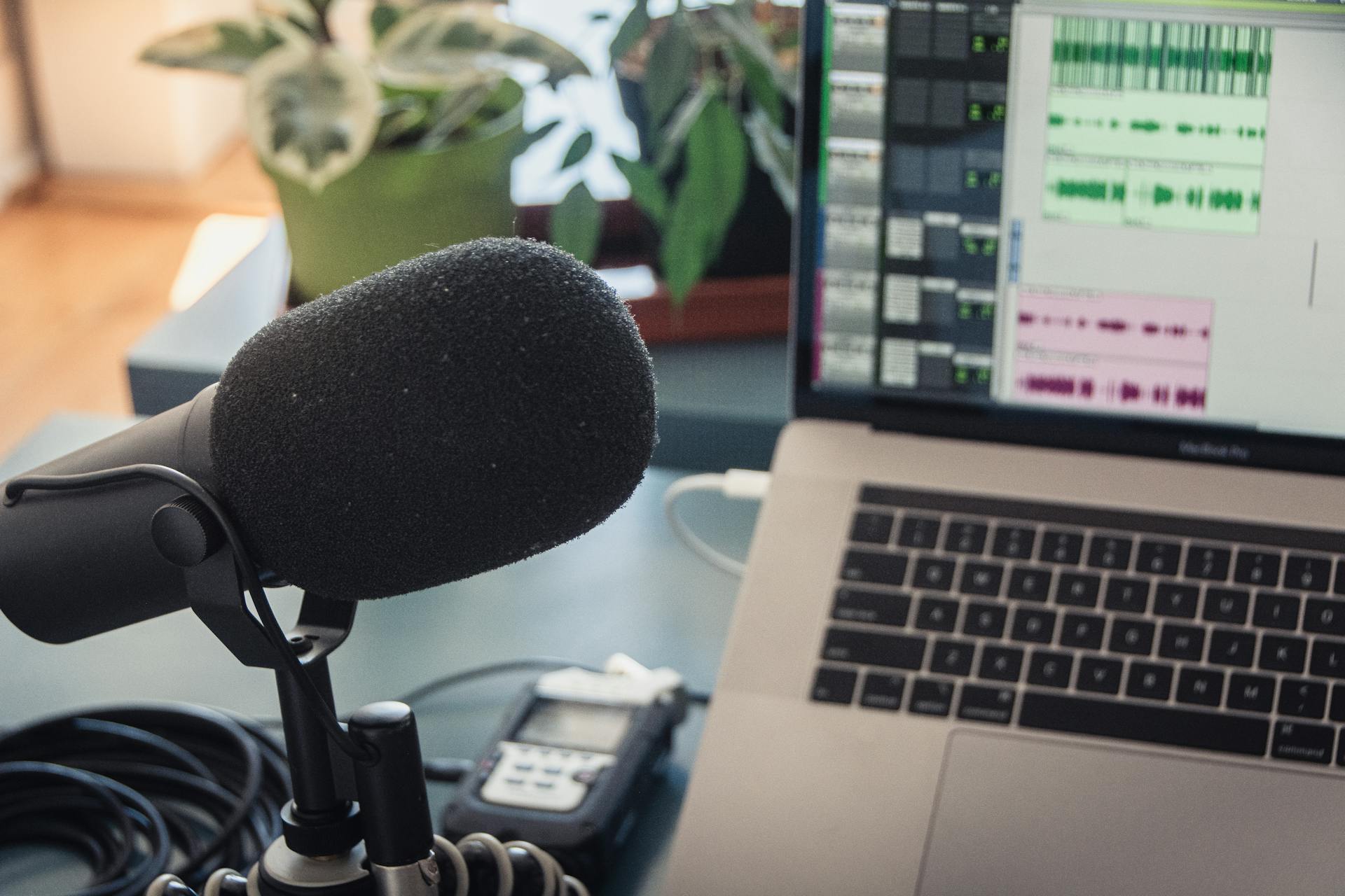 A podcast recording setup with a laptopmicrophoneand audio equipment indoors.