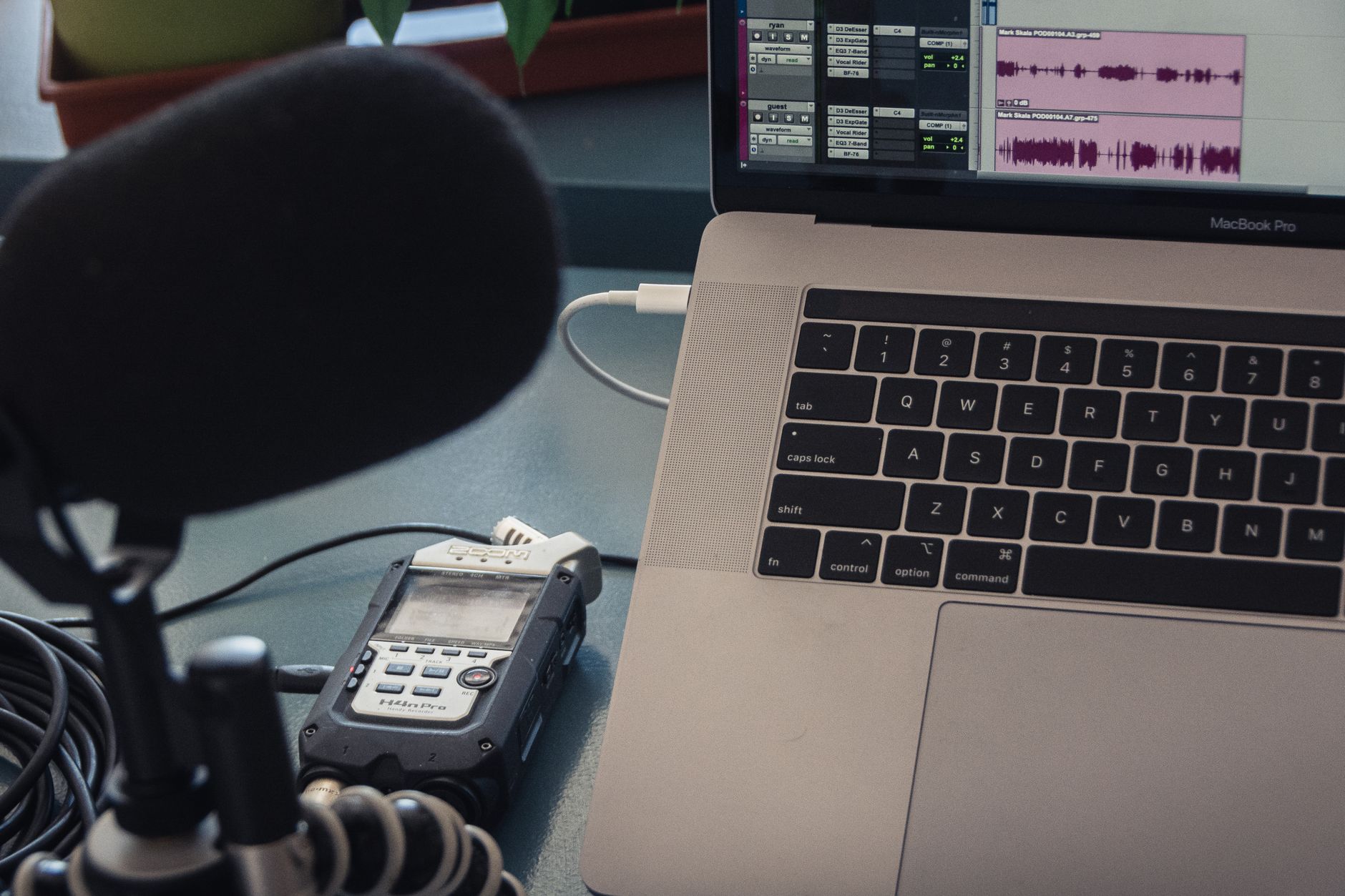 Microphone and laptop setup for audio recording in a studio environment.