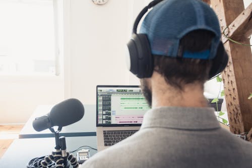 Man in Gray Sweater Wearing Blue Headphones