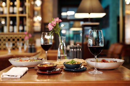 A Wine Glass and Ceramic Plates on a Wooden Table