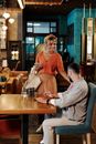 Man in Gray Dress Shirt Sitting Beside Woman in Orange Dress