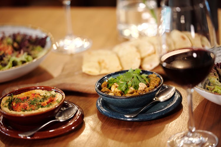 A Ceramic Bowl With Foods On A Wooden Table