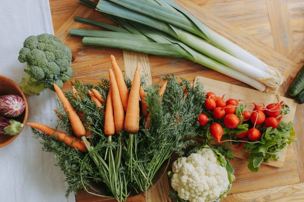 Fresh carrots, leeks and radishes on a wooden board — photo by Yaroslav Shuraev on Pexels