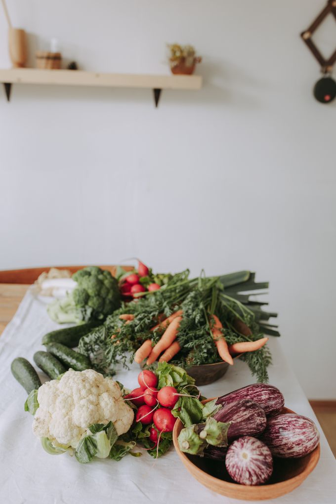 Variedade de vegetais frescos como couve-flor, cenoura, rabanete e berinjela sobre uma mesa