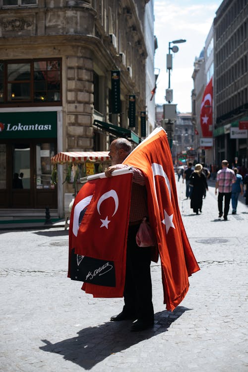 Old man selling red flags on street