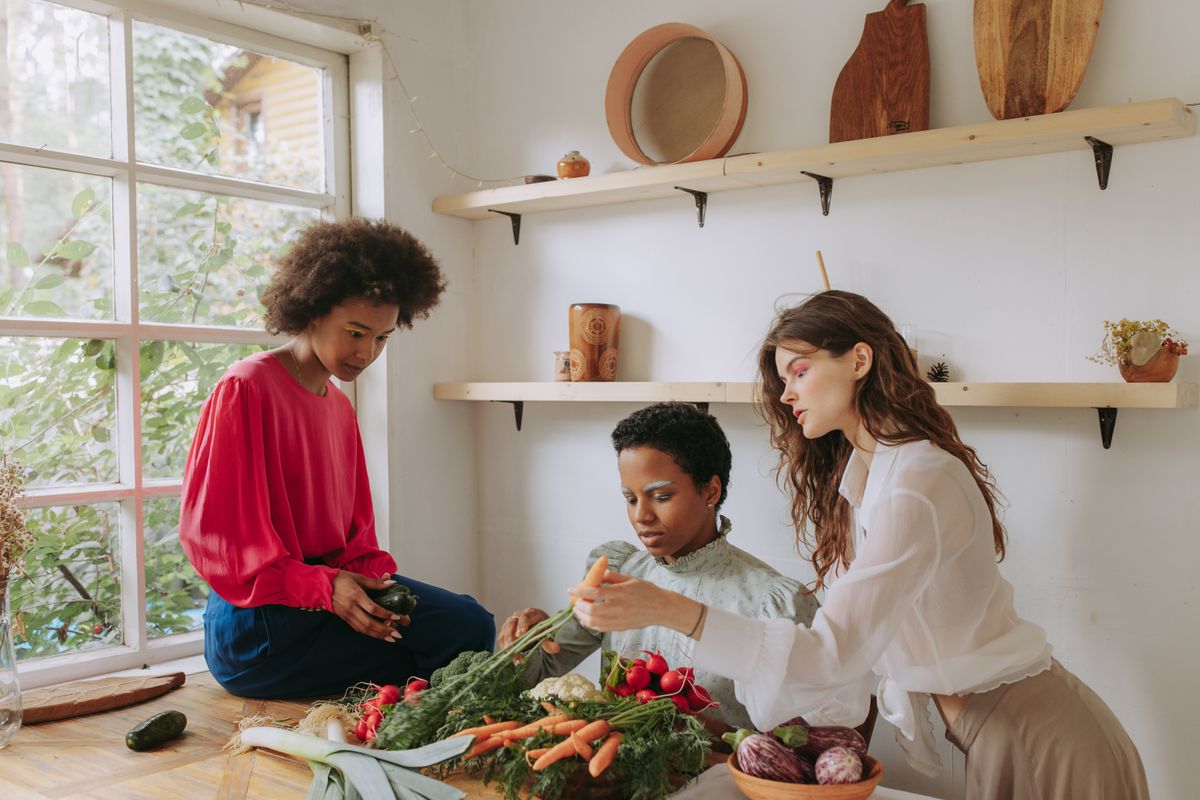 Three cooks prepping vegetables in a bright kitchen, photo by Yaroslav Shuraev on Pexels