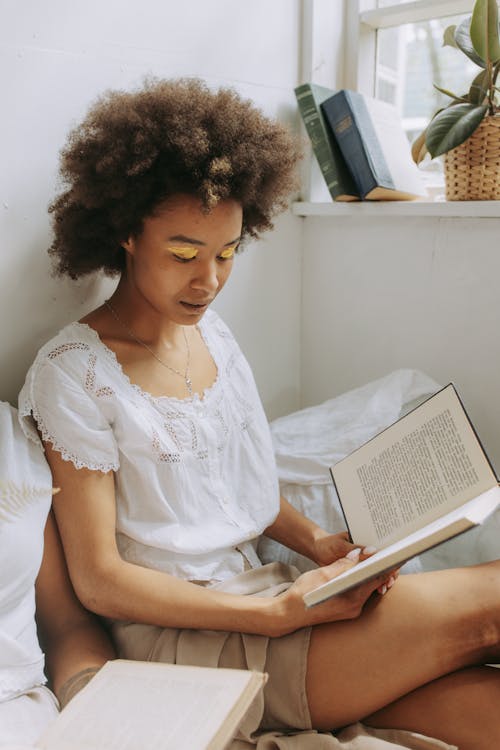 Free Woman Sitting and Reading A Book Stock Photo