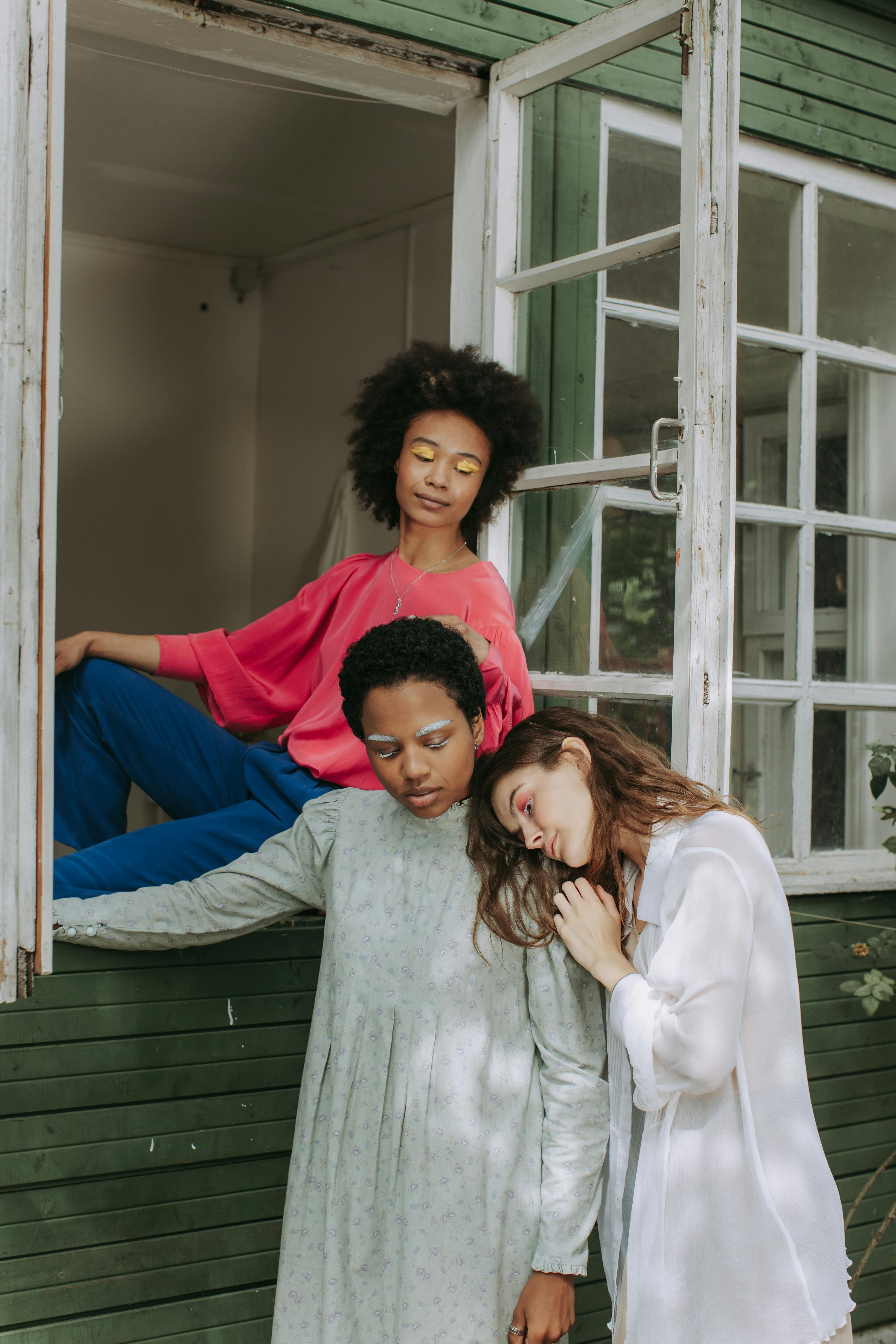 woman in white long sleeve shirt beside woman in red long sleeve shirt