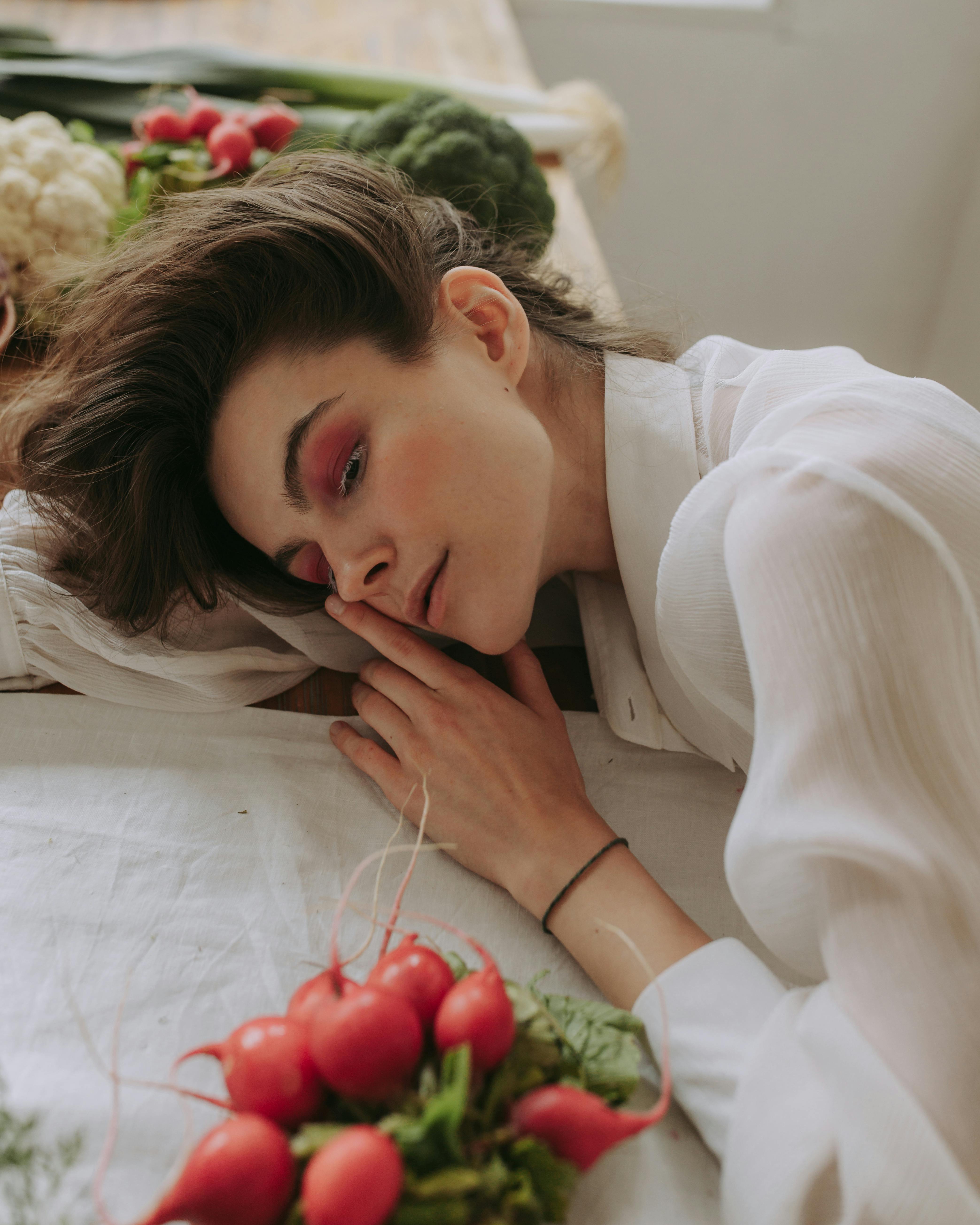 woman in white long sleeve shirt holding red rose