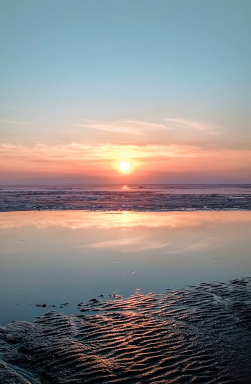 Sun on Sky during Sunrise over Sea Shore