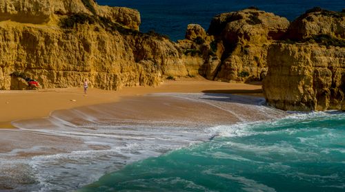 Free Vibrant beach scene with limestone cliffs and turquoise ocean waves under a bright sun. Stock Photo