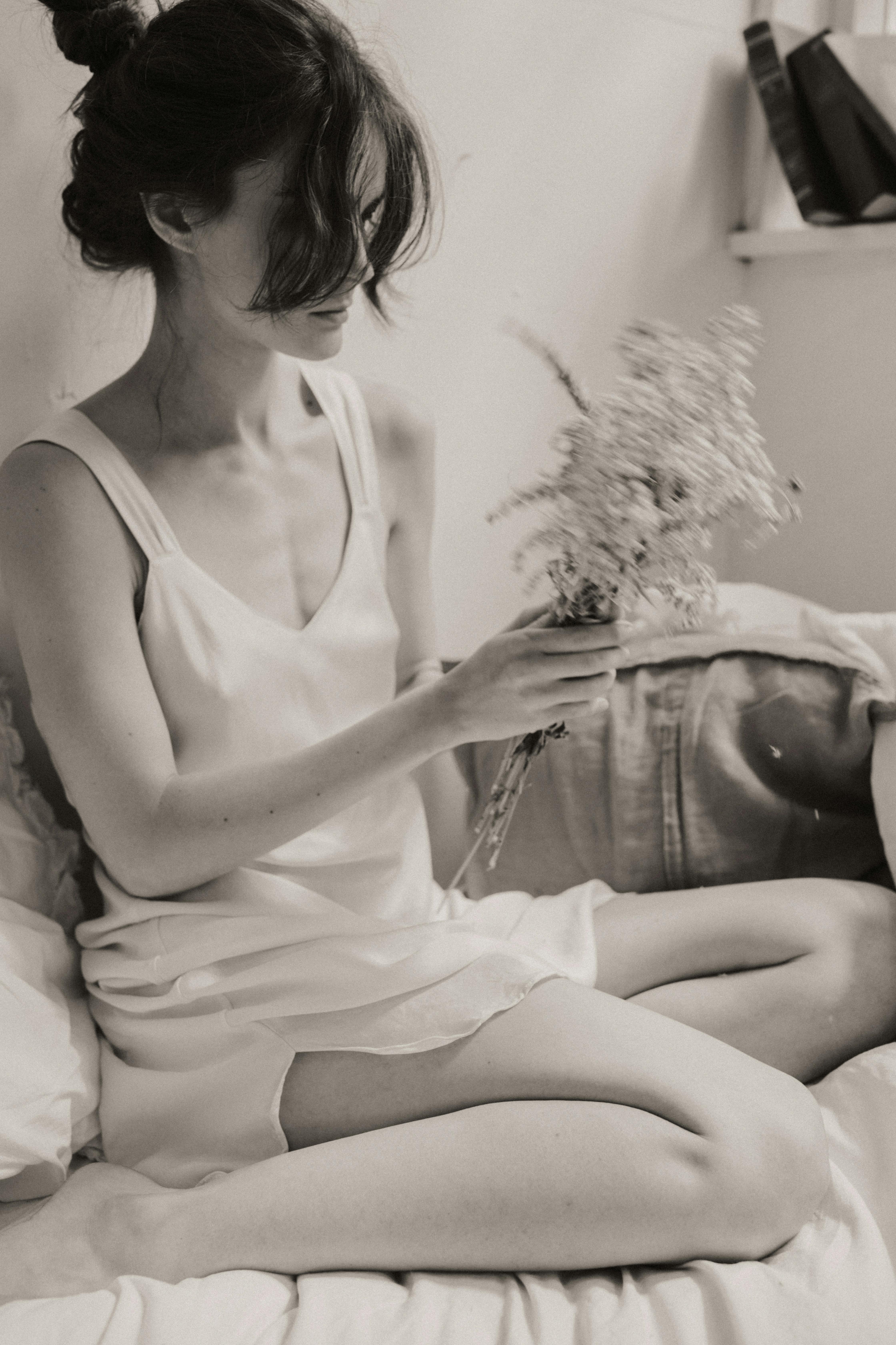 黑白照片中，一位手持鲜花的女子散发着优雅与平静