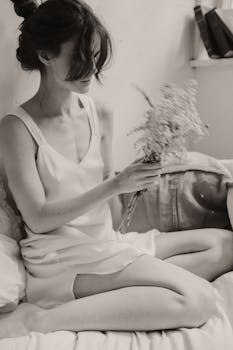 黑白照片中，一位手持鲜花的女子散发着优雅与平静