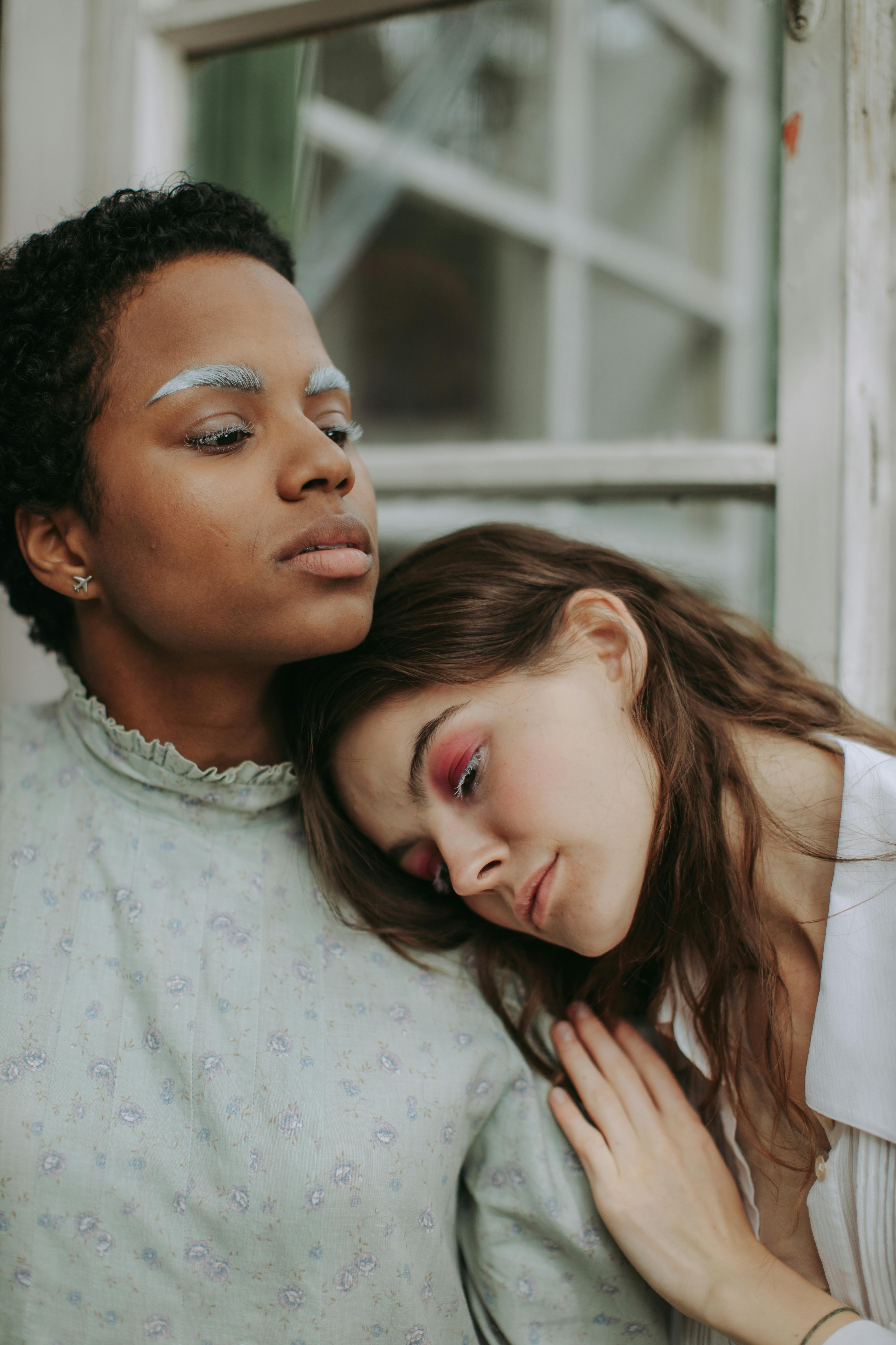 woman resting her head on the shoulder of another woman