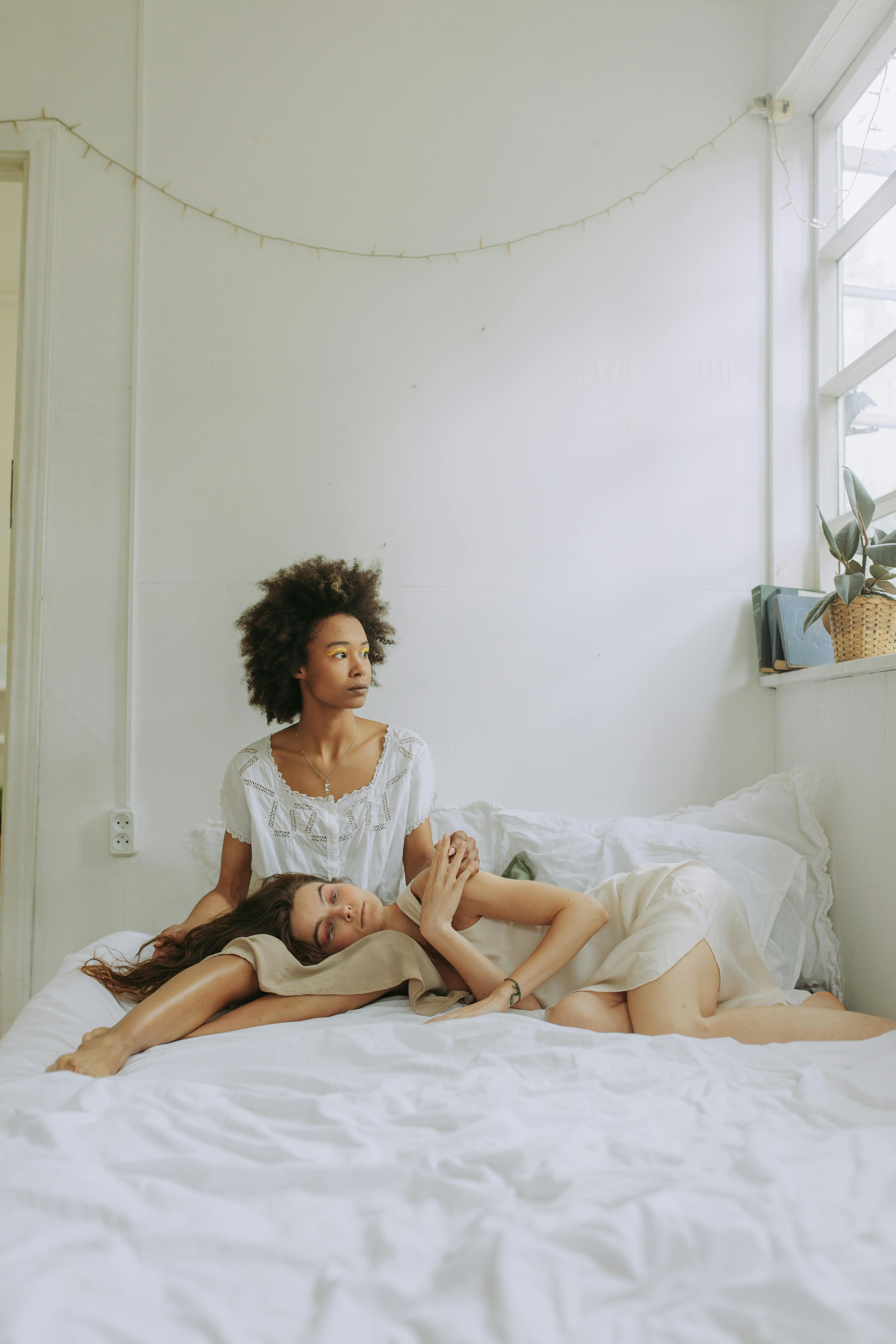 woman in white shirt sitting on bed