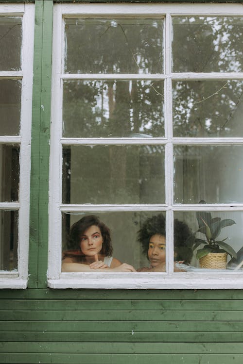 Woman in White Dress Sitting Beside Window