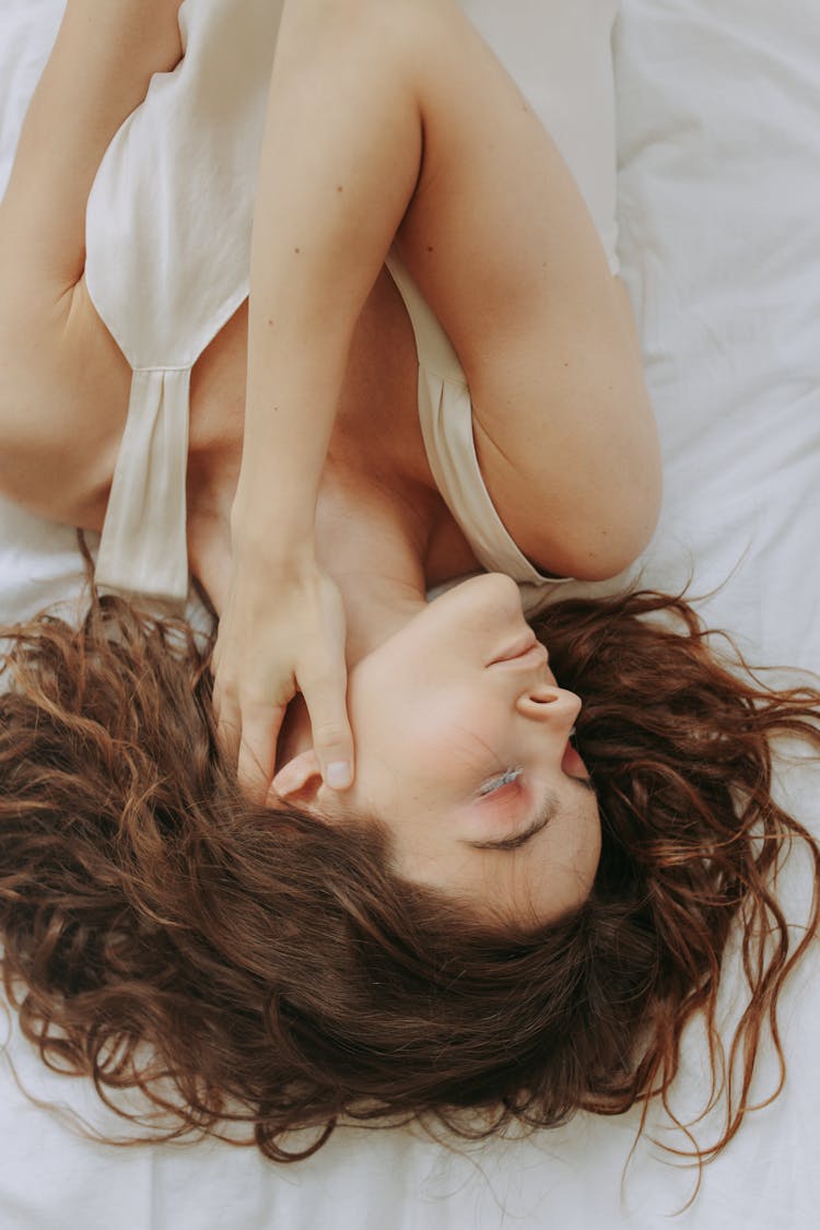 Woman In White Tank Top Lying On Bed