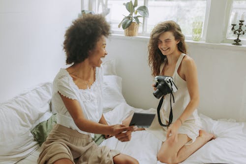 Woman in White Tank Top Sitting Beside Woman in White Tank Top