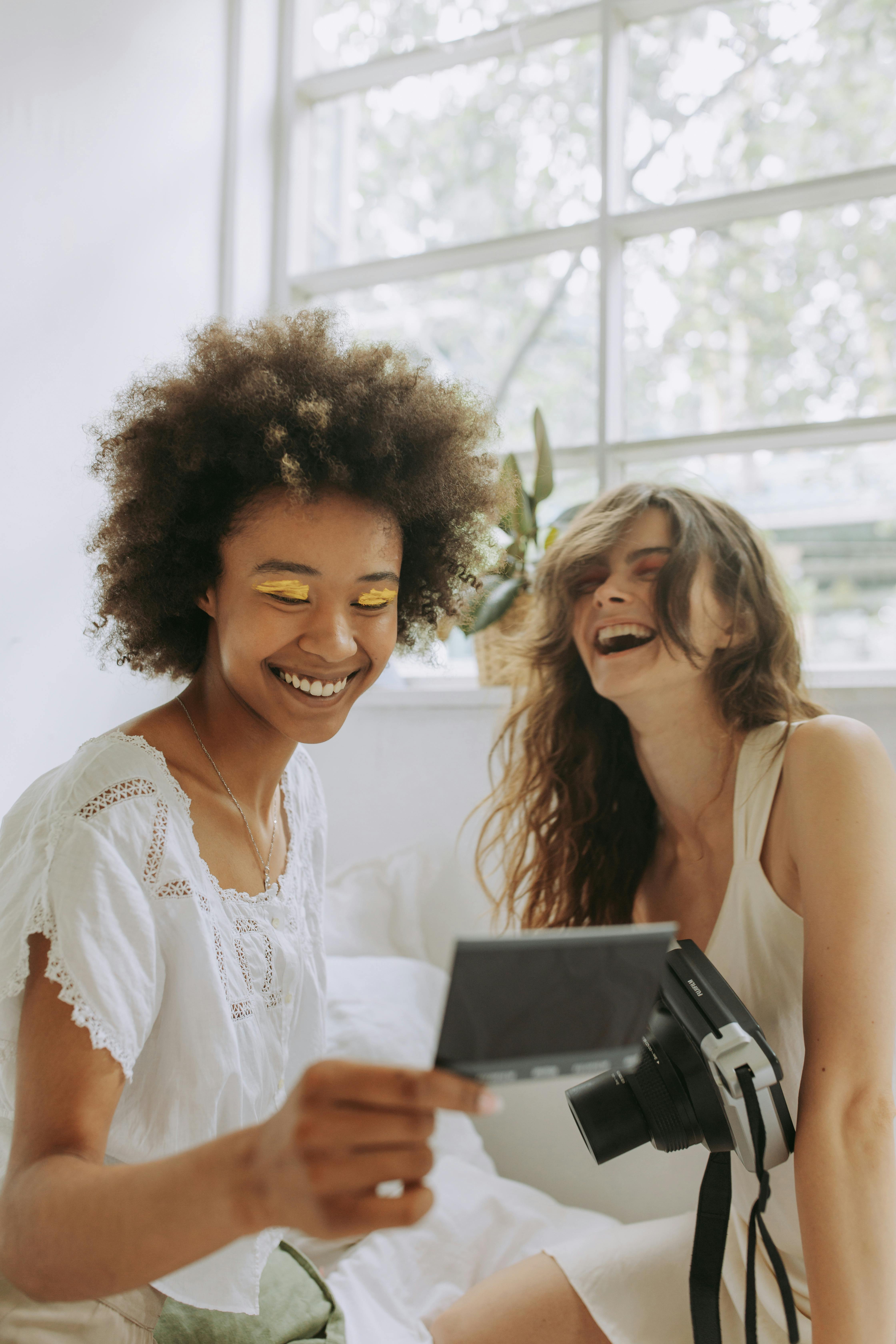 women laughing at a photograph