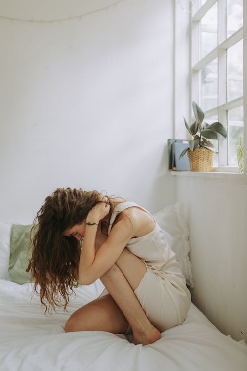 Free Woman With Messy Hair Sitting on Bed  Stock Photo