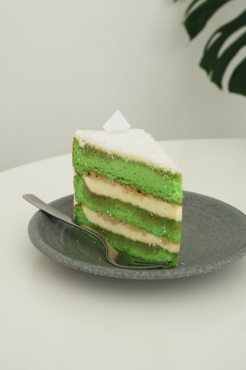 Free A Slice of a Green and White Cake on a Plate Stock Photo