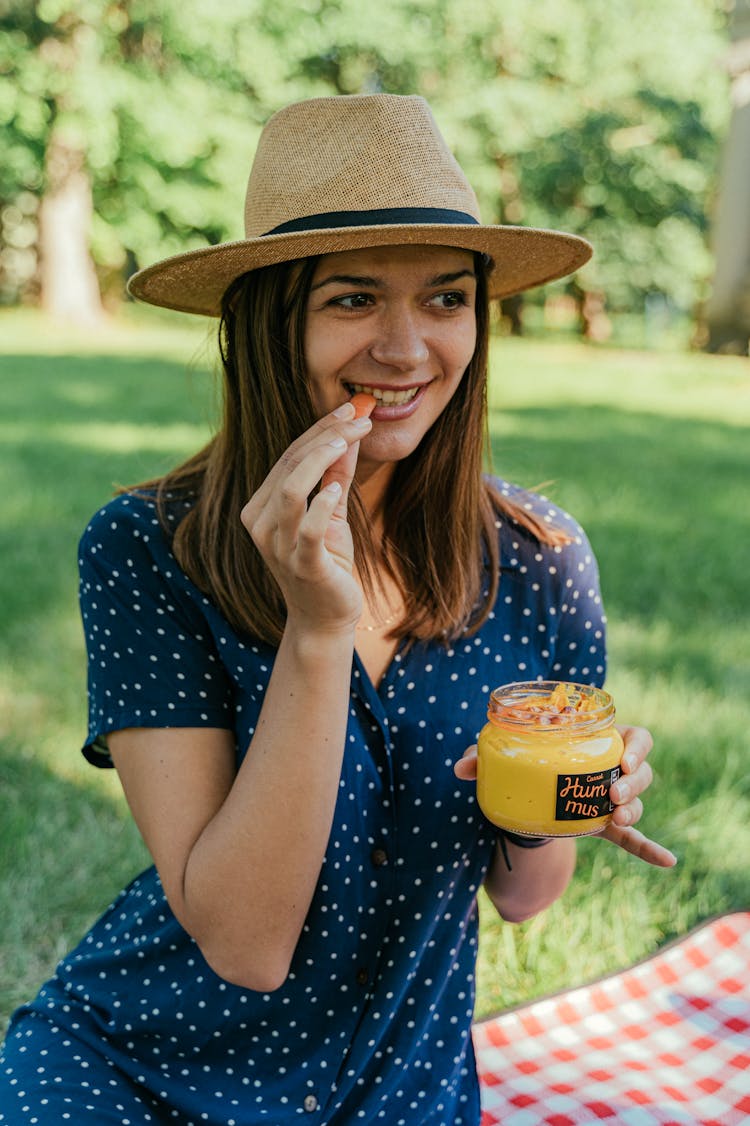 Woman Eating While Holding A Jar