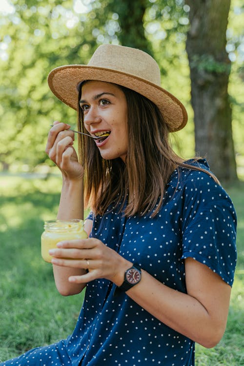 Woman Wearing Hat Eating with a Spoon