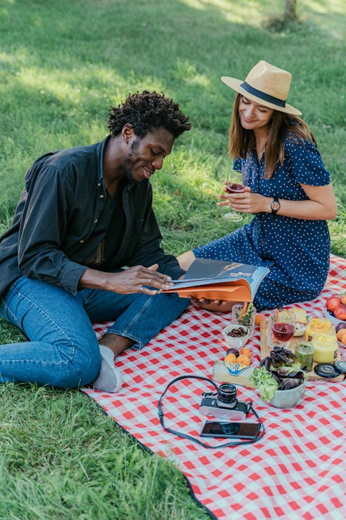 A Couple Reading a Book while Having a Picnic