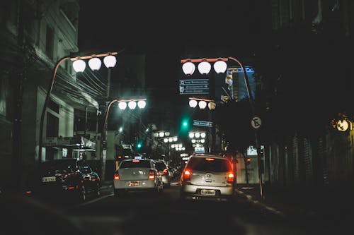 Vehicles on Road Between Buildings