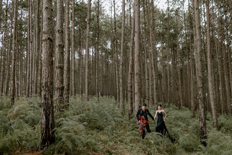 Young Couple Walking In Bushy Forest