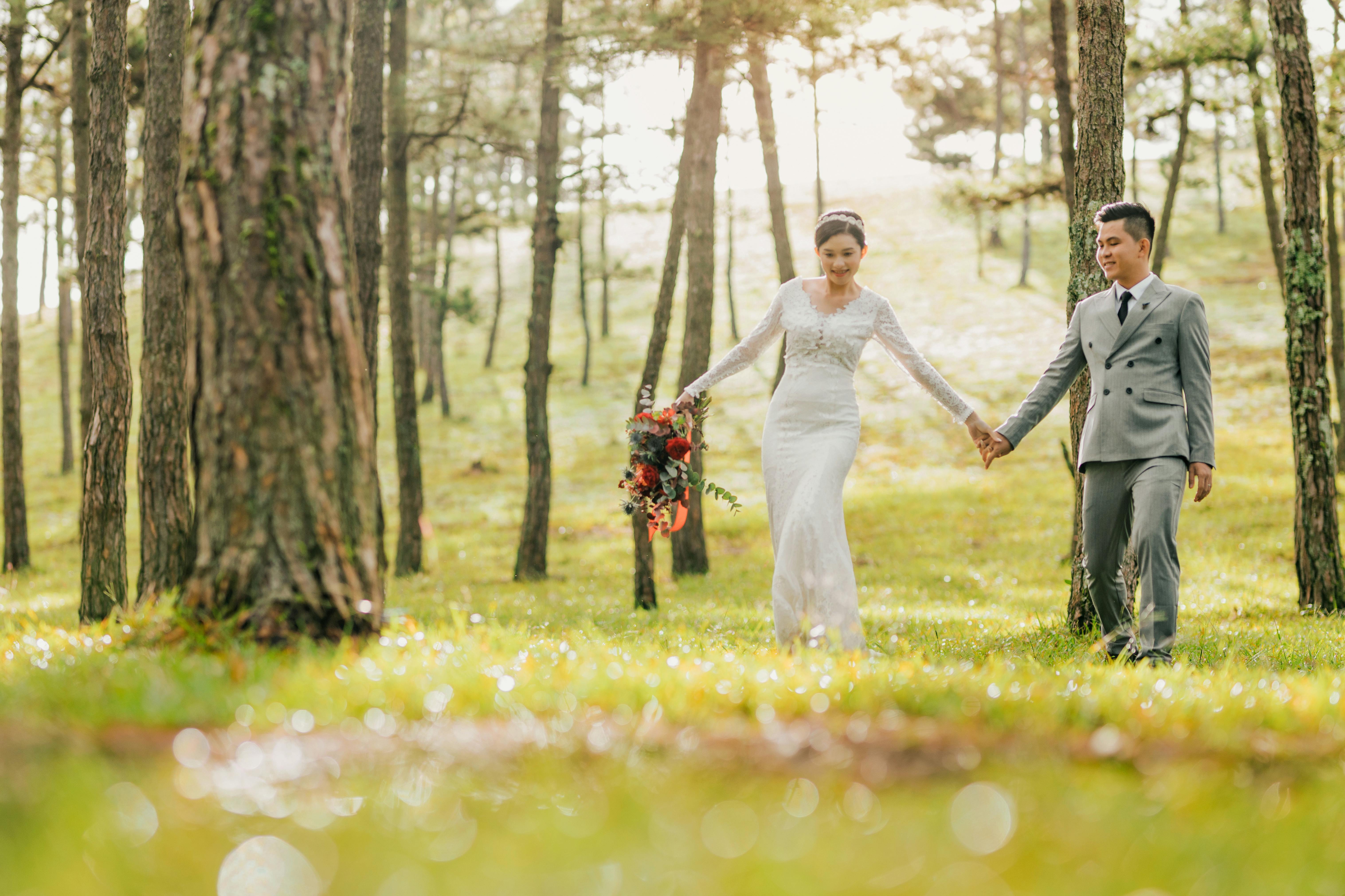 happy cheerful asian couple holding hands in forest