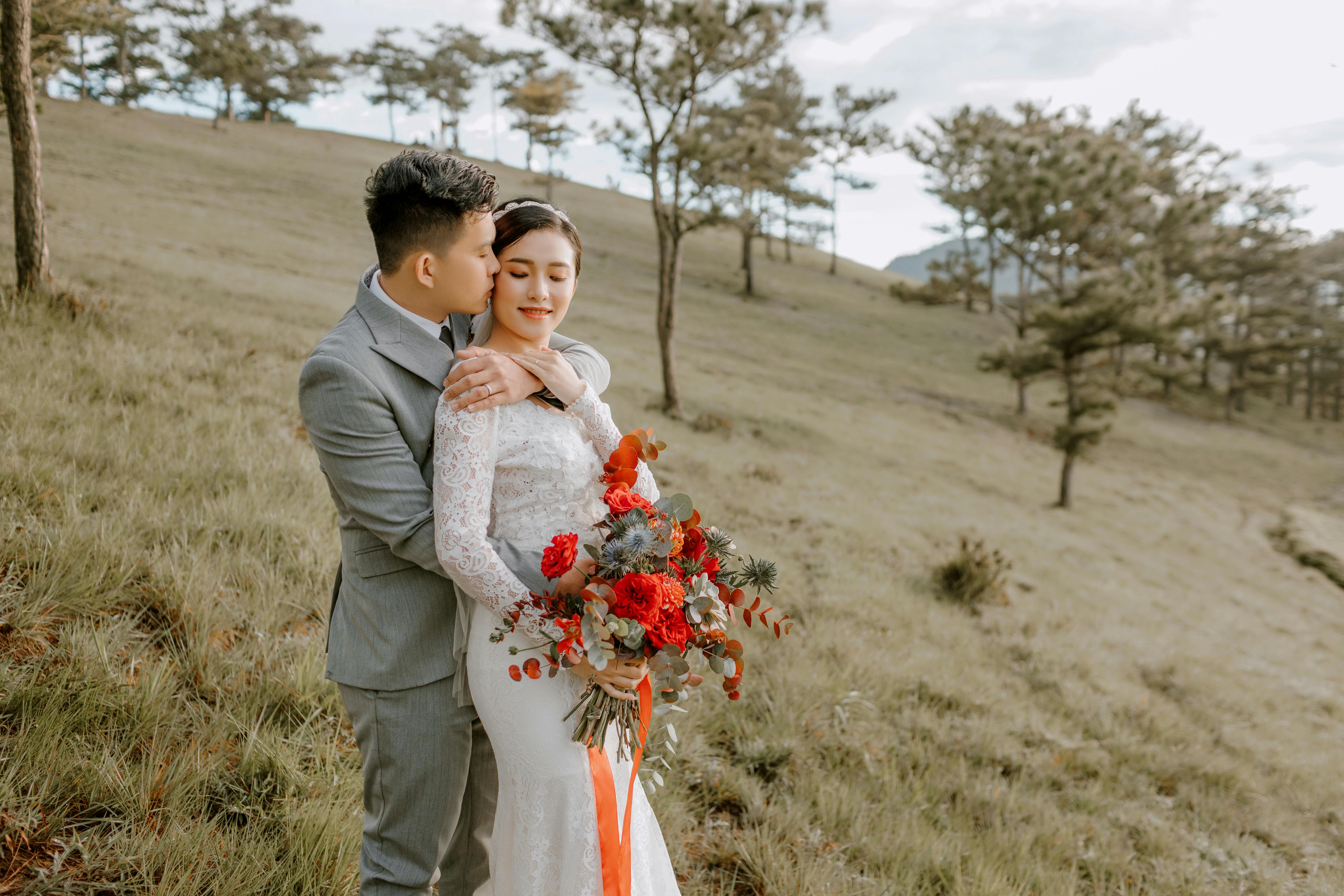 happy cheerful asian couple embracing on slope