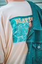 Close-up of Young Mans Back Wearing a Graphing T-shirt and a Jean Jacket Thrown Over Shoulder 