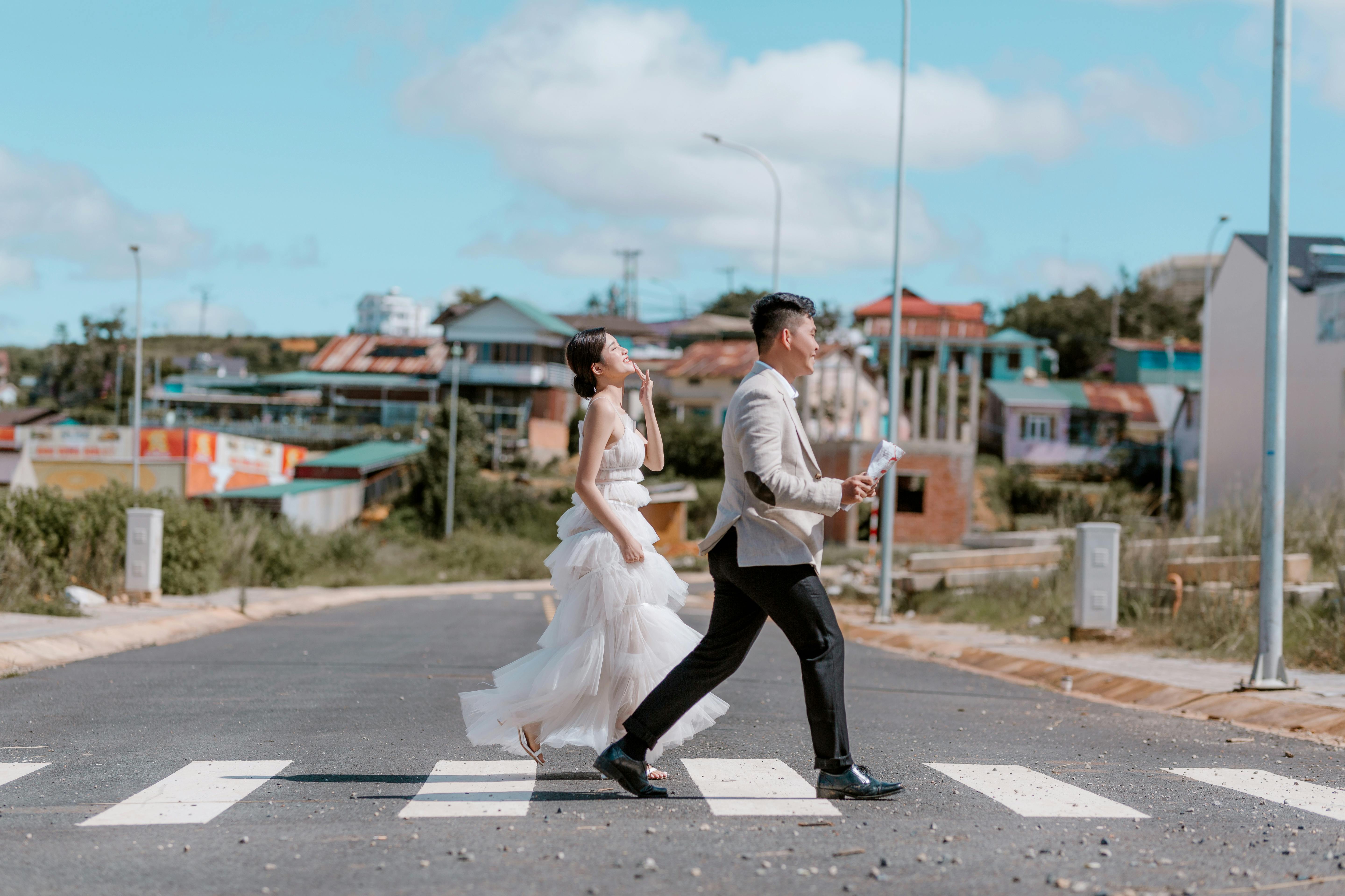 Happy ethnic newlyweds on road in city