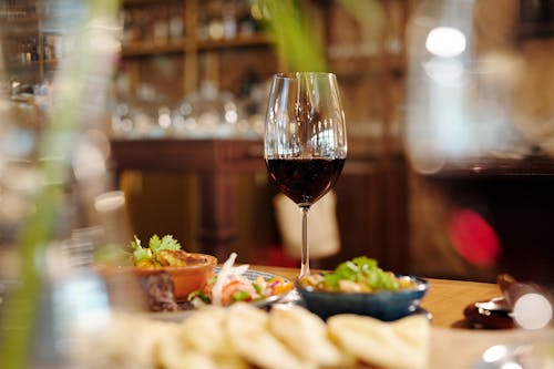 Copa De Vino Transparente Con Vino Tinto En La Mesa