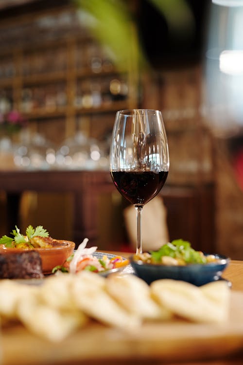 Copa De Vino Transparente Con Vino Tinto En La Mesa