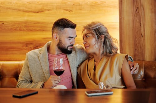 Couple Sitting Close Together While Drinking Red Wine 