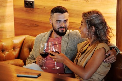 Couple holding wine glasses together in a stylish restaurant