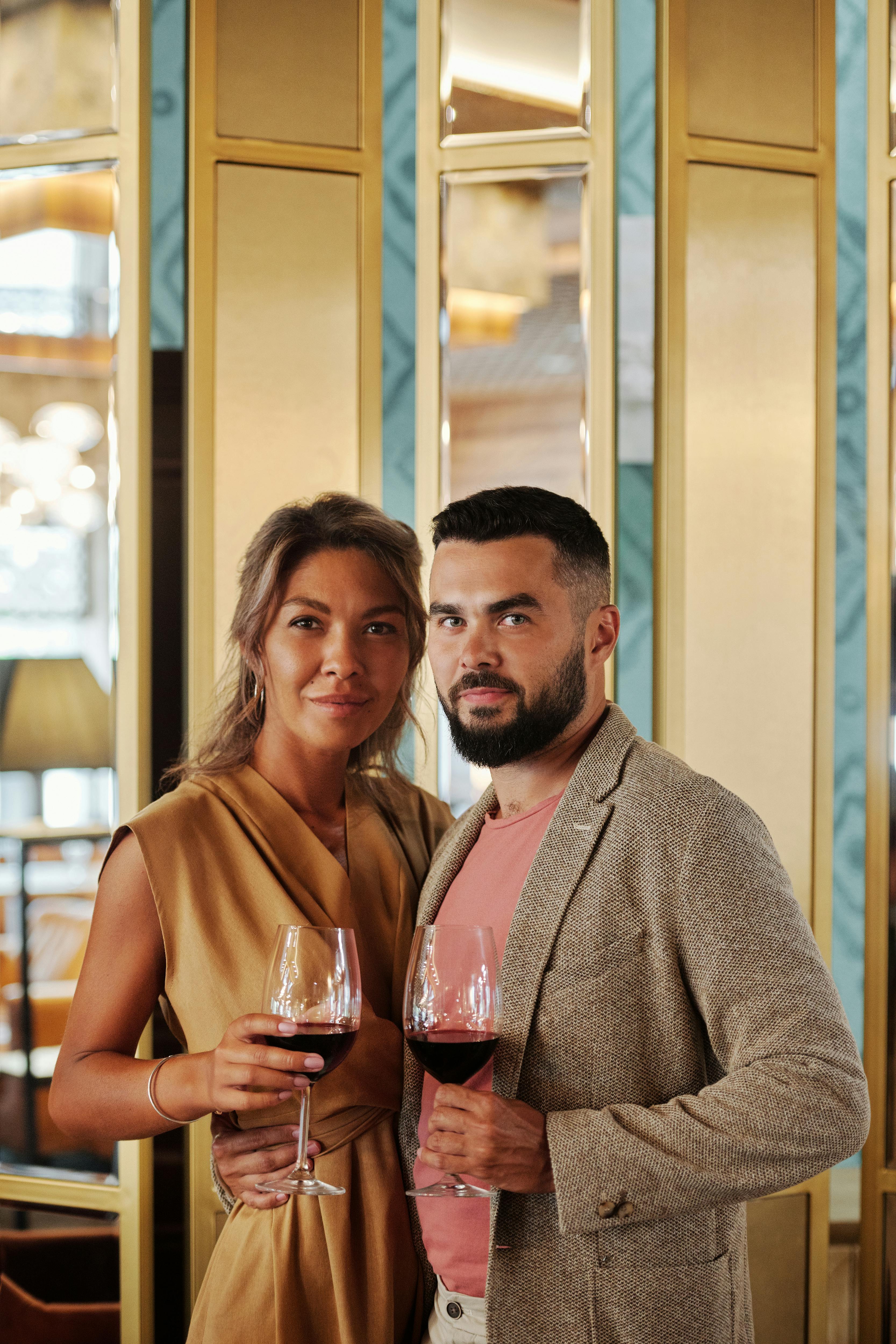 loving couple standing holding wine glasses