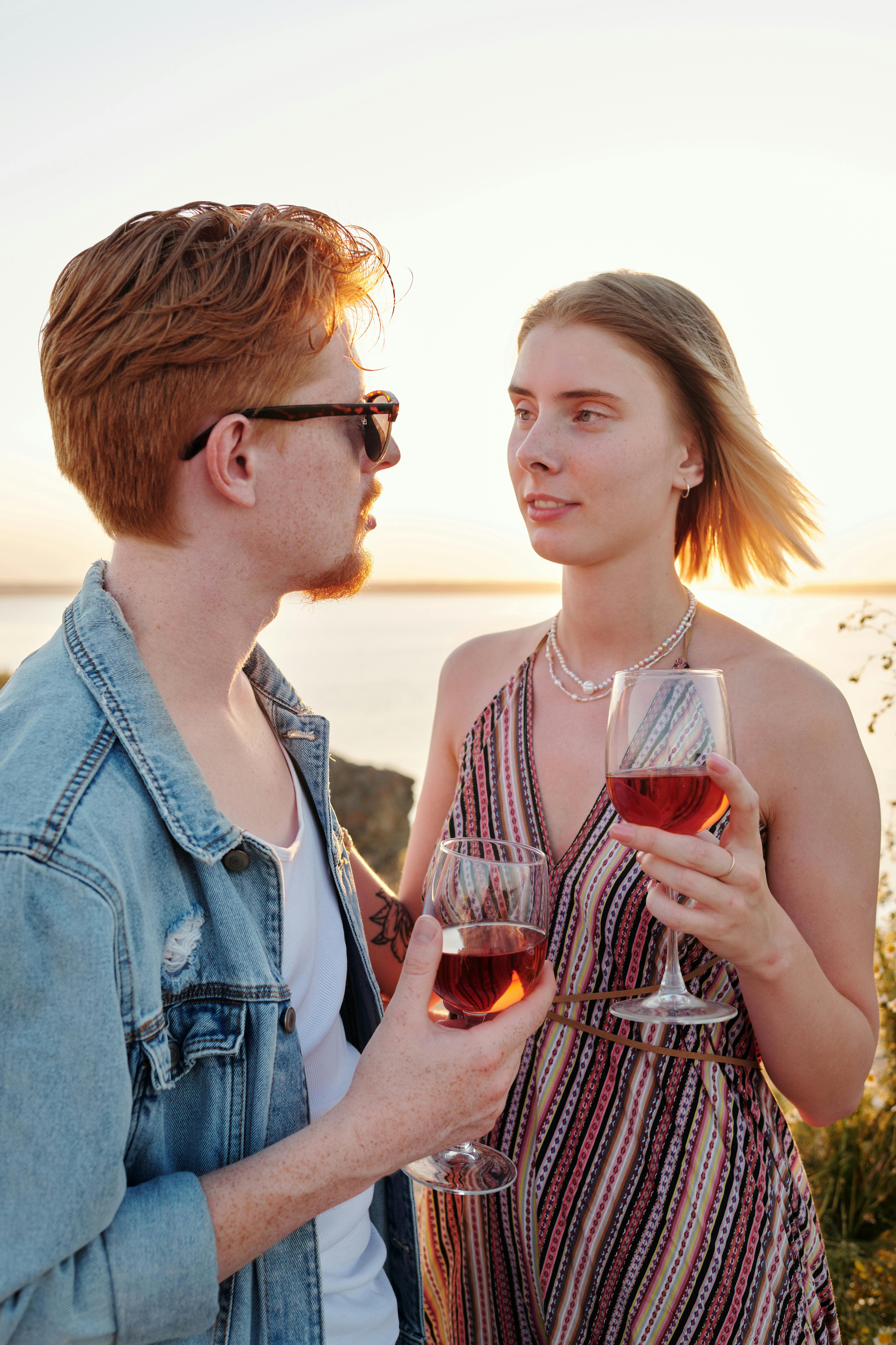 a couple holding a glass of wine while looking at each other