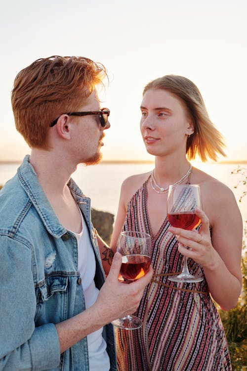 A Couple Holding a Glass of Wine while Looking at Each Other