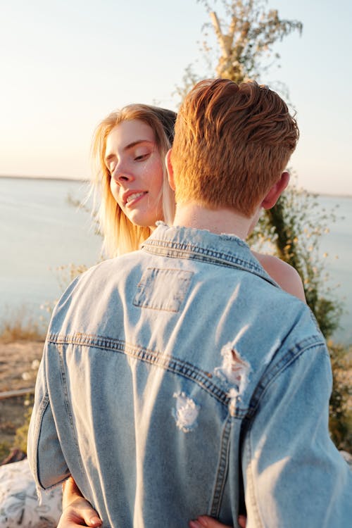 Man in Denim Jacket Kissing a Woman 