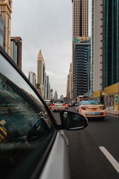 多云天空下，现代摩天大楼与繁忙交通构成了城市街景