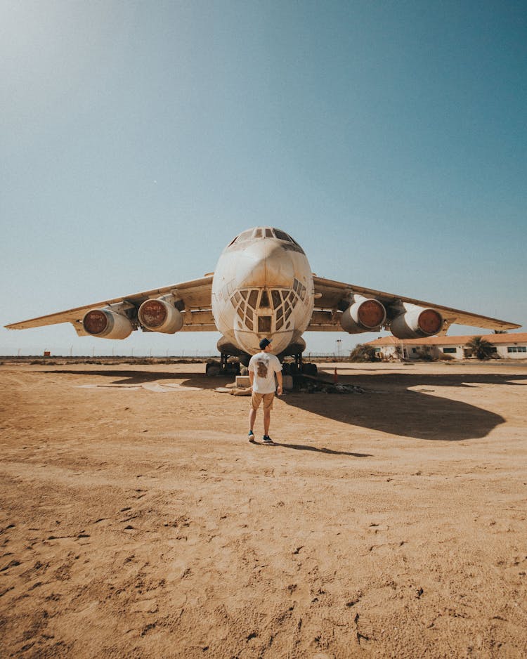 A Man Standing In Front Of A Jumbo Plane