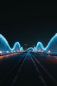 迪拜梅丹桥的壮丽景色，在夜空中亮起蓝色的灯光