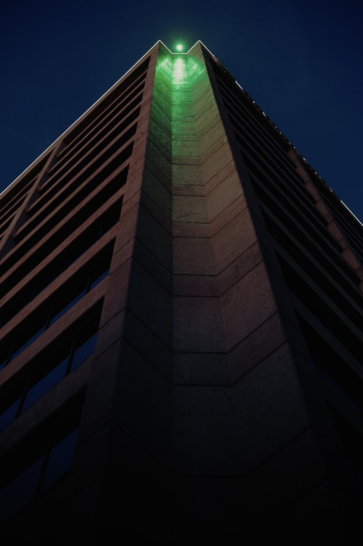 Green Roof Light On Tall Building Corner At Night