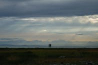 Green Grass Field Under Cloudy Sky