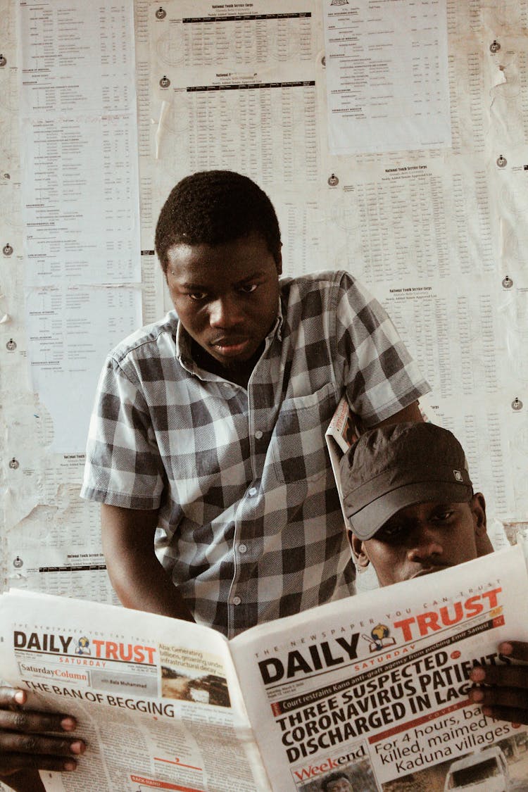 Men Reading Newspaper Together